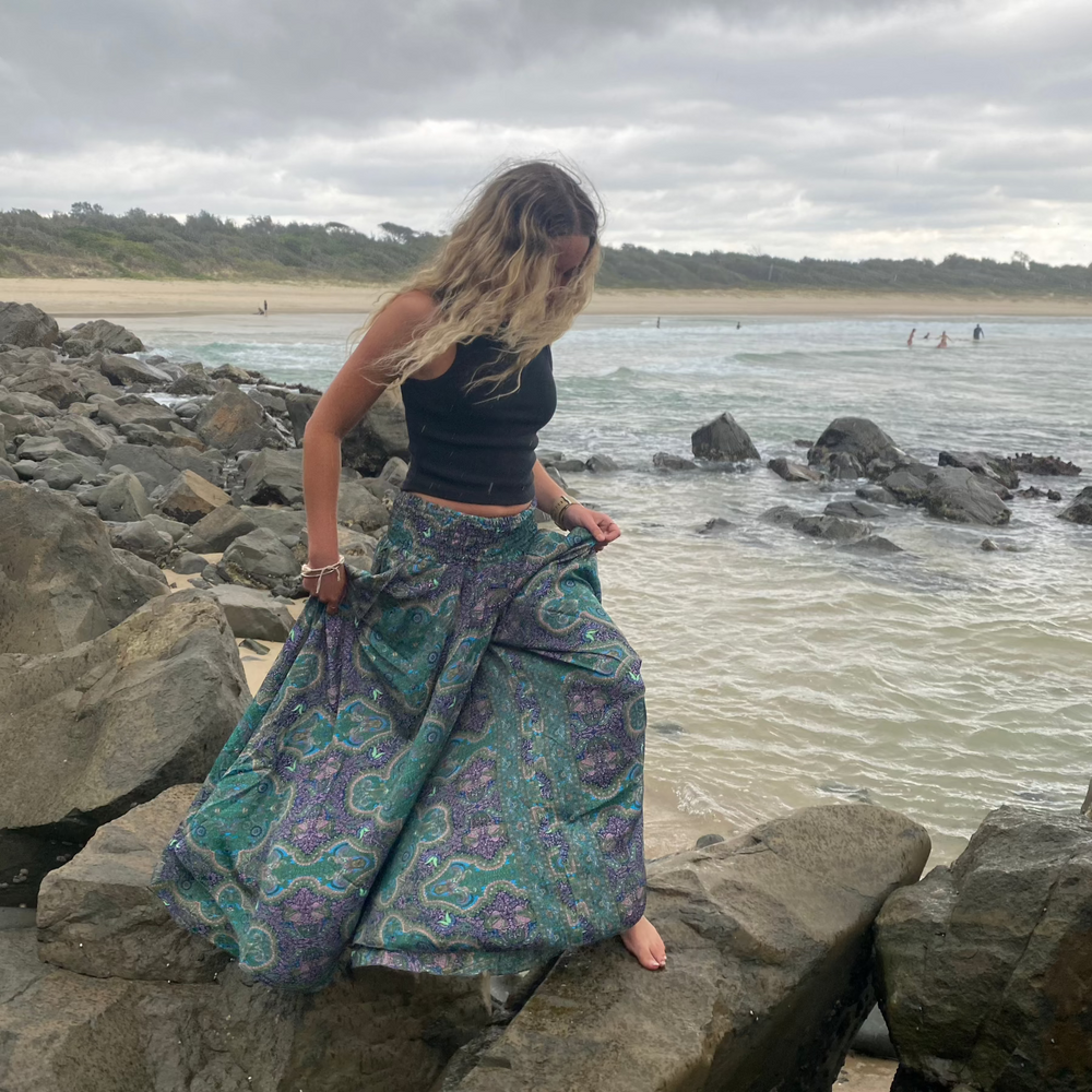 Woman wearing Soulsister Free Spirit Pants climbing across rocks